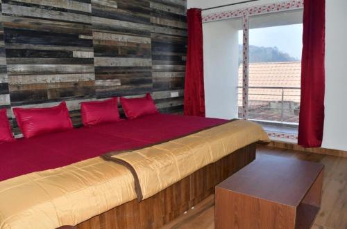 a bedroom with a bed with red pillows and a window at Zeeenu Abode Yercaud by GD in Yercaud