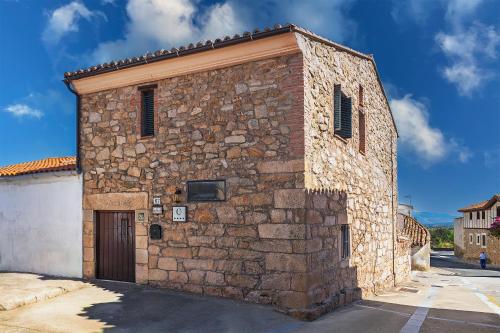 a stone building with a door on a street at El Regreso in Jarilla