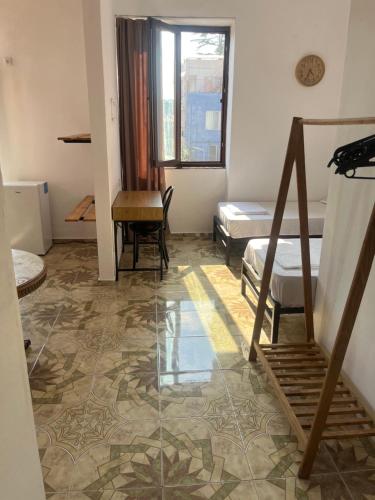 a room with a bed and a desk and a table at Olympia Ureki Guria Street 24-26 in Ureki