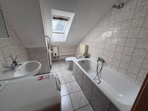 a bathroom with a sink and a tub and a toilet at Comfortable and functional apartment in Kretzschau