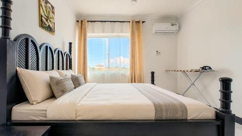 a bedroom with a large bed with a large window at City Getaway Apartments in Zanzibar City