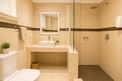 a bathroom with a toilet and a sink and a shower at Royal Solwezi Hotel in Solwezi