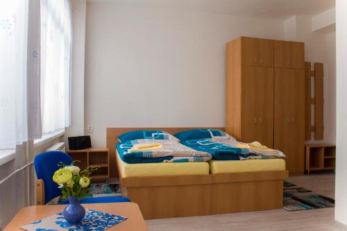 ŠD Urbánkova 2 في كوشيتسه: غرفة نوم بسرير وخزانة خشبية