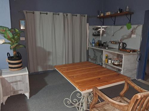 a kitchen with a wooden table in a room at Beit Philodemus 2 - IRIS in Um Qeis
