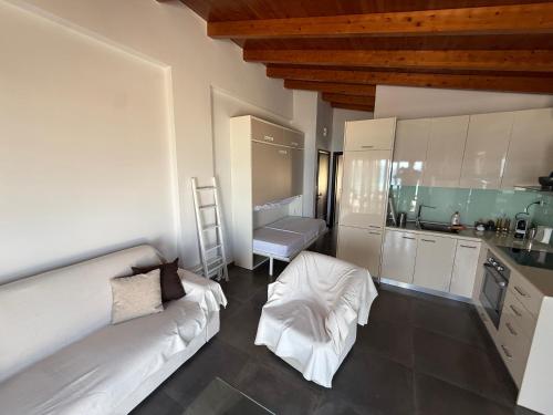 a living room with a white couch and a kitchen at Korelis Apartments in Agia Anna