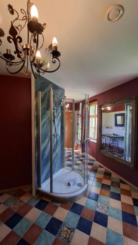 a glass shower in a room with a checkered floor at Wein-Hotel Auberge Mistral in Freiberg