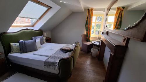 a small bedroom with a bed and a mirror at Wein-Hotel Auberge Mistral in Freiberg