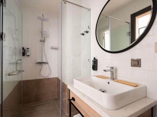 a bathroom with a sink and a shower with a mirror at Ibis Tashkent Index in Tashkent