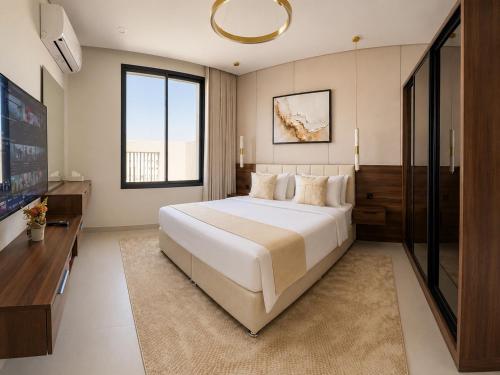 a bedroom with a large bed and a flat screen tv at الاخشبان in Jeddah