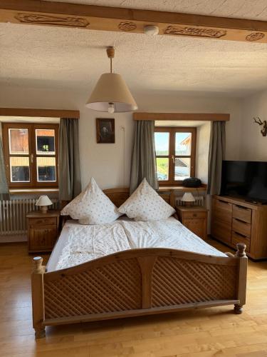 a bedroom with a large bed and a television at Schwaigerhof Rottau in Rottau