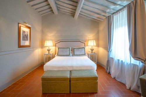a bedroom with a large bed and two windows at Relais Villa Olmo - Place of Charme in Impruneta
