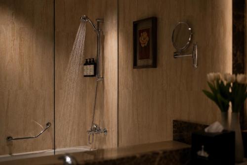 a shower in a bathroom with a sink at Crown Tower Hotel in Al Jubail
