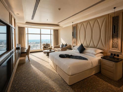 a hotel room with a large bed and a television at Crown Tower Hotel in Al Jubail