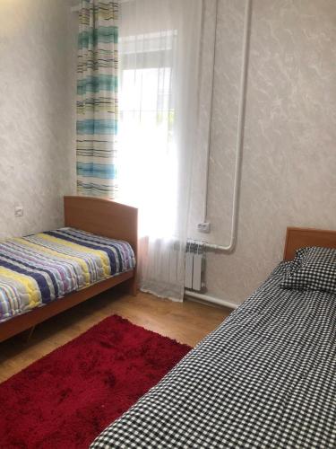 a bedroom with two beds and a window at Чолпон-Ата Коттедж in Cholpon-Ata