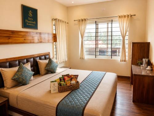 a bedroom with a bed with a basket of food on it at Srj's Thaneesh Residency in Ooty