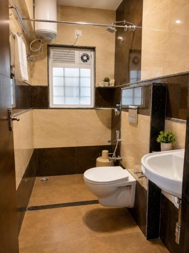 a bathroom with a toilet and a sink at Srj's Thaneesh Residency in Ooty