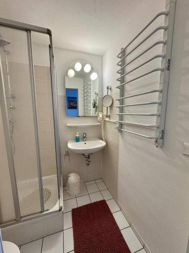 a bathroom with a shower and a sink and a mirror at Hotel Gästehaus Altena in Altena