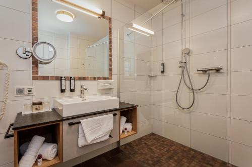 a bathroom with a sink and a shower at Hotel Almrausch in Saalbach-Hinterglemm