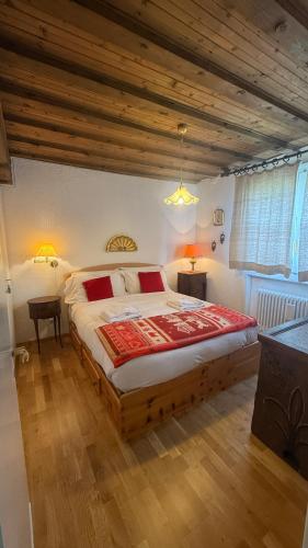 a bedroom with a large bed and a wooden ceiling at Cosy Lodge un rifugio romantico nel cuore delle Dolomiti in Madonna di Campiglio