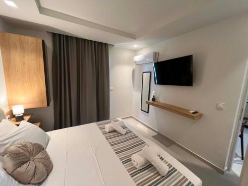 a hotel room with a bed and a flat screen tv at Nestia Residences in Kardamaina