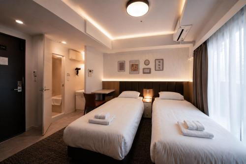 a hotel room with two beds and a bathroom at Hotel Arashi Nippombashi 2 No008 in Osaka