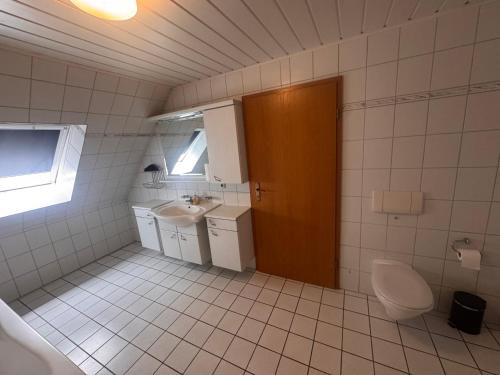 un bagno bianco con WC e lavandino di Hotel Rademacher a Wittmund
