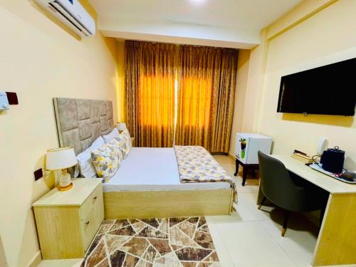 a bedroom with a bed and a desk with a computer at Mudha Hotel in Hargeysa