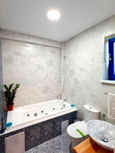 a bathroom with a tub and a toilet and a sink at Agropensiunea Paradisul Verde in Jurilovca