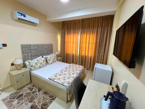 a bedroom with a bed and a table and a window at Mudha Hotel in Hargeysa