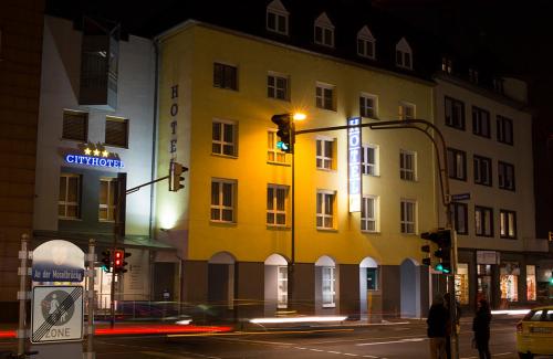 a yellow building on a city street at night at City-Hotel Kurfürst Balduin in Koblenz