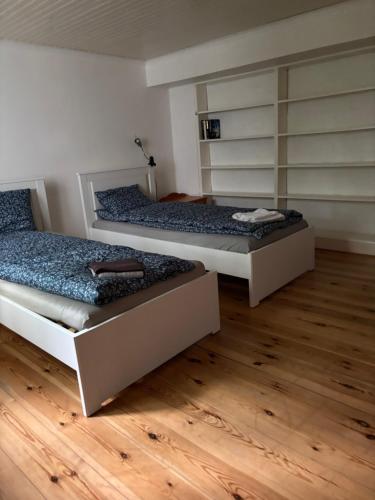 two beds in a room with wooden floors at Storgatan 42 in Högsby