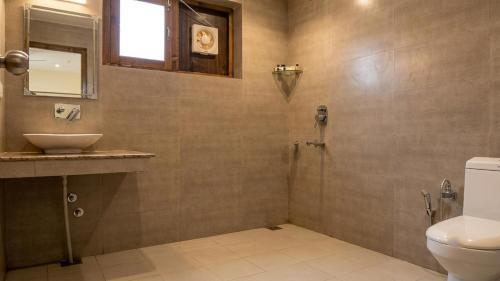 a bathroom with a shower and a sink and a toilet at Green View Hotel in Leh