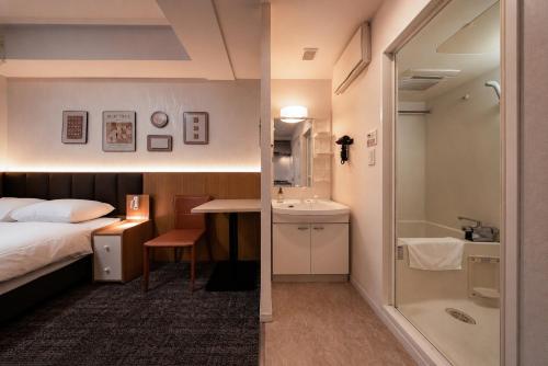 a bedroom with a bed and a bathroom with a shower at Hotel Arashi Nippombashi 2 No008 in Osaka