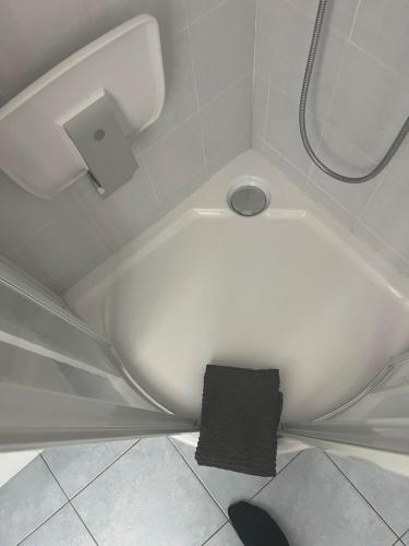 a white bath tub in a bathroom with a black towel at Maison Agathe in Brussels