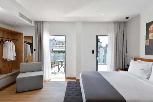 a bedroom with a large white bed and a chair at Acropolis Lumina in Athens