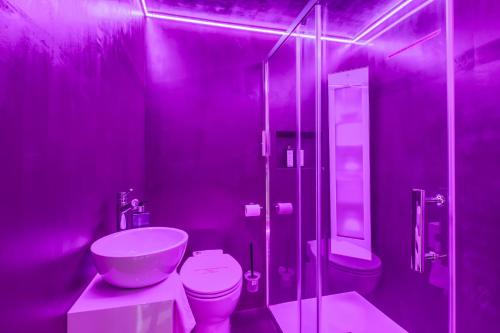 a purple bathroom with a toilet and a shower at TOWNHOUSE TROUVILLE - Appart'Hotel & Spa in Trouville-sur-Mer