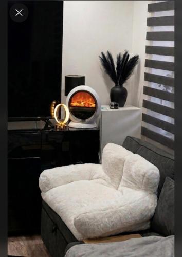 a living room with a white chair and a pizza oven at Blackapartment2Kawalerka in Olsztyn