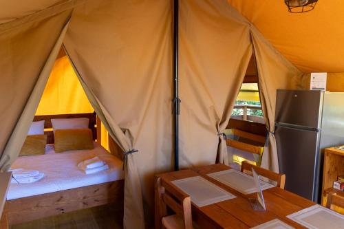 a small tent with a table and a refrigerator at Domaine Solio - Lodge isolée, nature, animaux in Satillieu