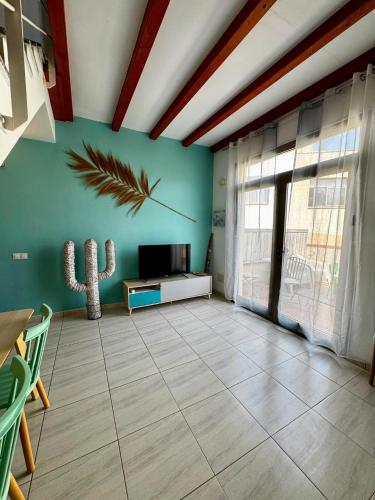 a living room with a flat screen tv and a cactus at Casa Gino in El Cotillo