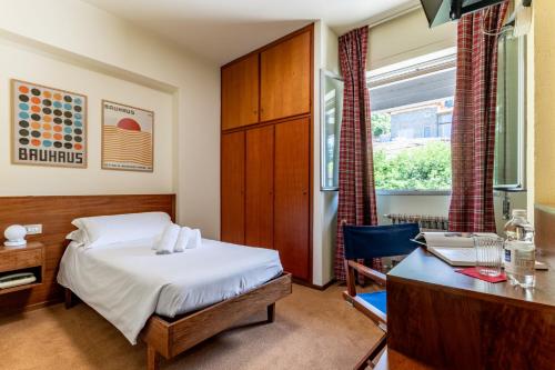 a hotel room with a bed and a desk and a desk at Dynamotel in San Marcello Pistoiese