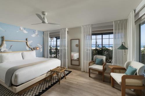 a bedroom with a large bed and a chair at The Milo in Santa Barbara