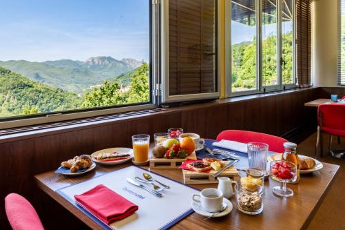 a table with food and a view of mountains at Dynamotel in San Marcello Pistoiese