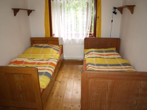 two beds sitting in a room with a window at Farma Rybníček in Pelhřimov