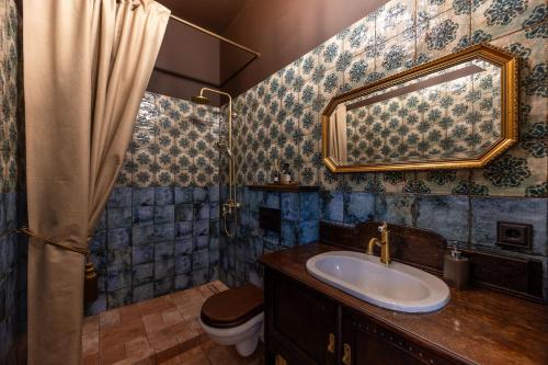 a bathroom with a sink and a toilet and a mirror at Galuonu Vilos Vip vila in Inturkė
