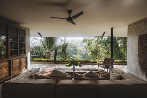 a living room with a couch and a ceiling fan at The Hidden Paradise Ubud - CHSE Certified in Ubud