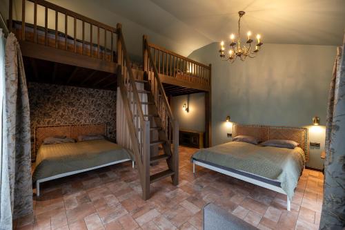a bedroom with two beds and a spiral staircase at Galuonu Vilos Vip vila in Inturkė