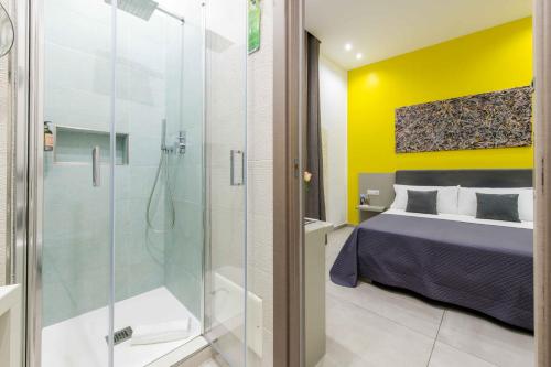 a bathroom with a glass shower and a bed at Toledo 16 Luxury Suites in Naples