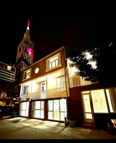 a building with lit windows and a building with a tower at HOTEL Old Boulevard BATUMI in Batumi