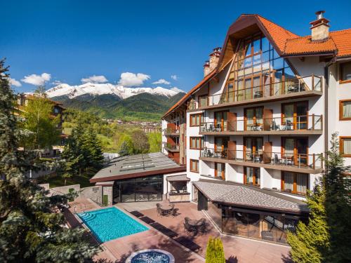 a hotel with a pool and mountains in the background at SPA Resort St Ivan Rilski - Halfboard & All Inclusive in Bansko