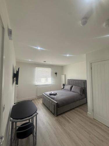 a bedroom with a bed and a table in it at CoolSideOfThePillow in Swindon